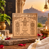 A square decorative card or print featuring a Devanagari inscription and a central figure with outstretched arms, styled on a stone surface with a temple sunset in the background, a brass lamp, flowers, and red petals.